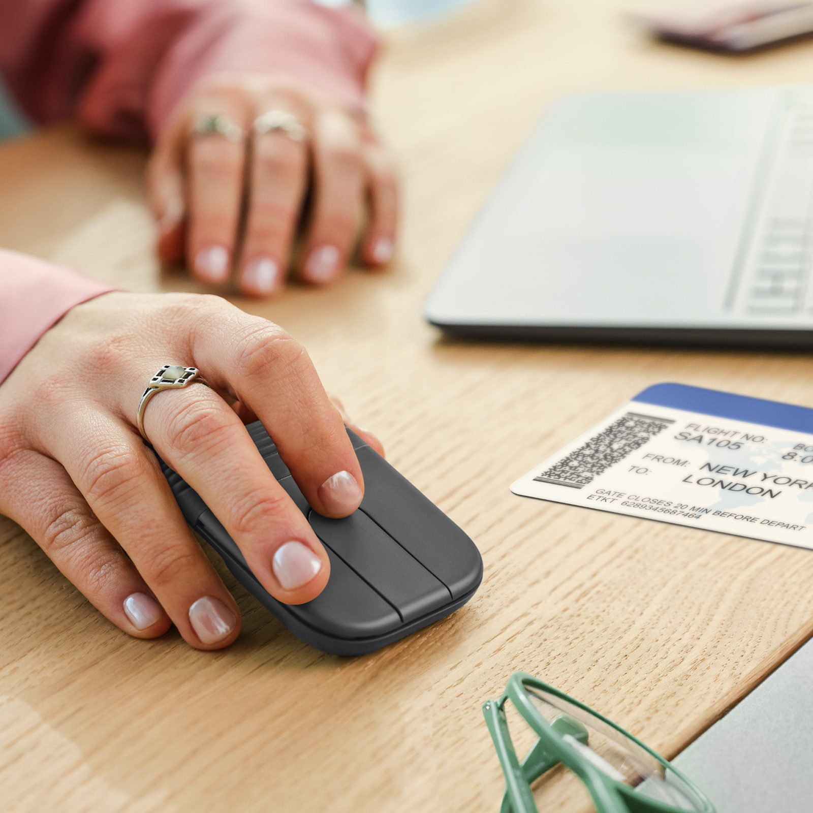 Logitech Mobi Fold mouse Graphite in use on a desk beside a laptop