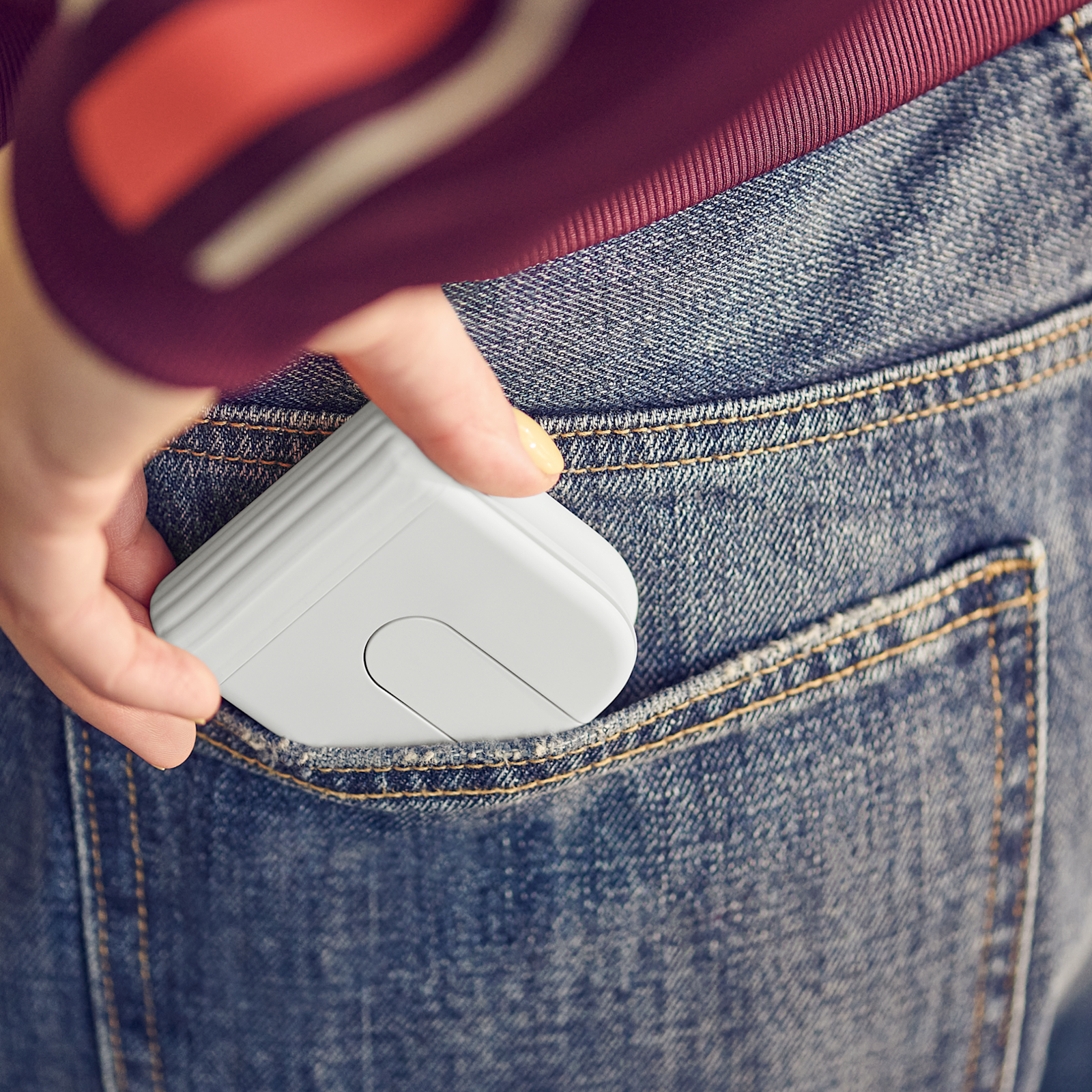 Logitech Mobi Fold mouse Off-White folded and slipping into a pocket
