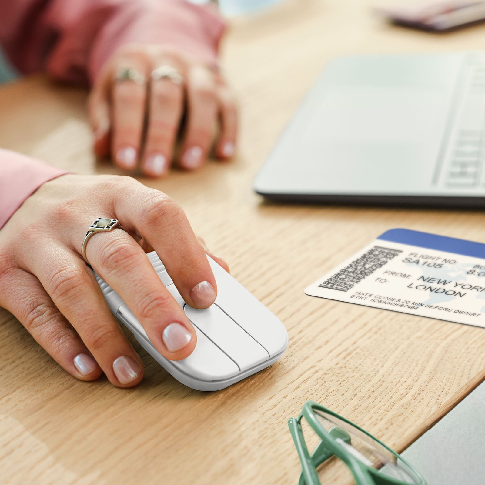 Logitech Mobi Fold mouse Off-White in use on a desk beside a laptop